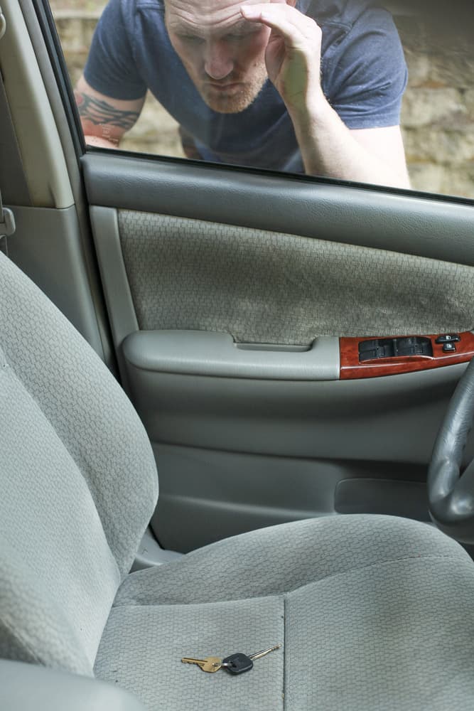 A man that is locked out of his car and requires car unlock services.