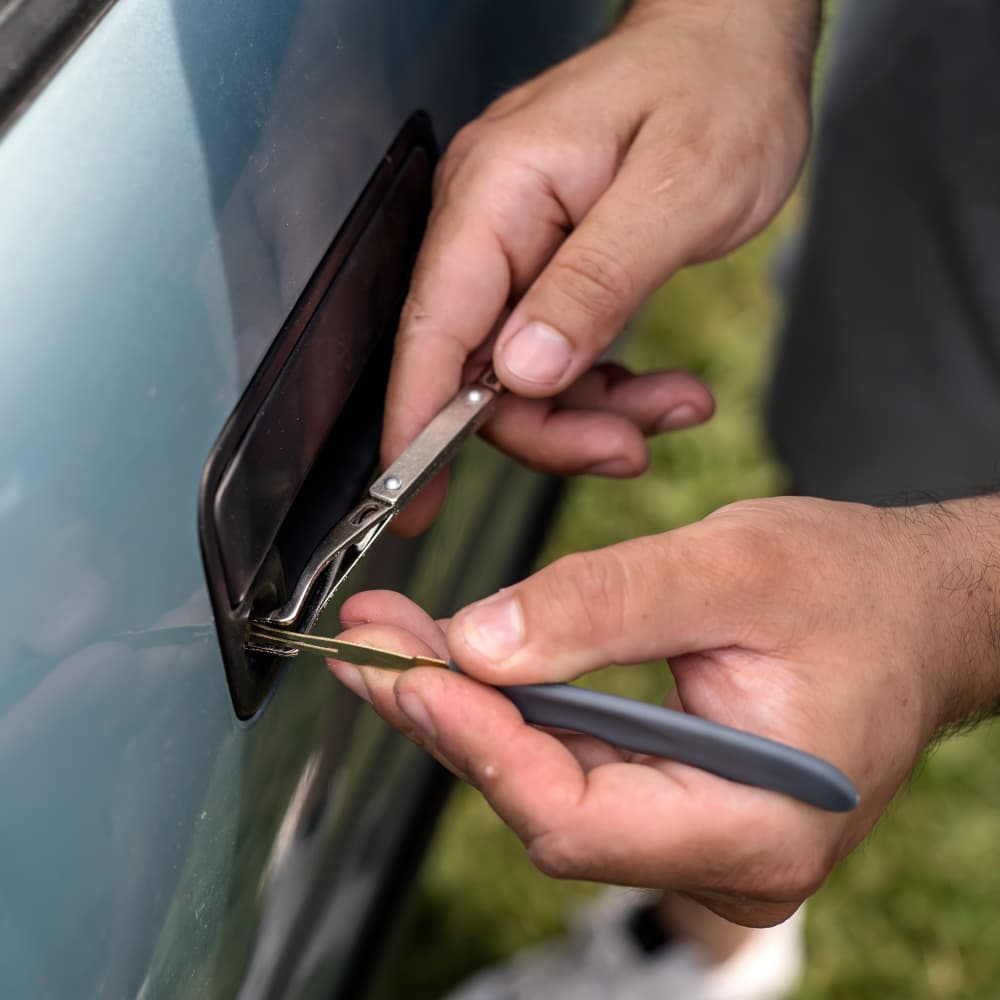 Male Mechanic Holding Lockpicker To Open Car Door, close up