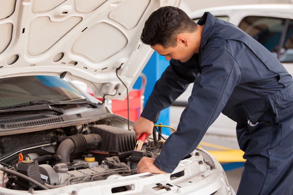 Mechanic jumpstarts a car battery in the Bronx.